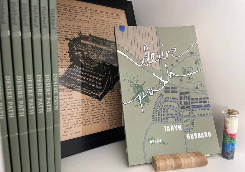 Copies of a green poetry book called Desire Path by Taryn Hubbarde